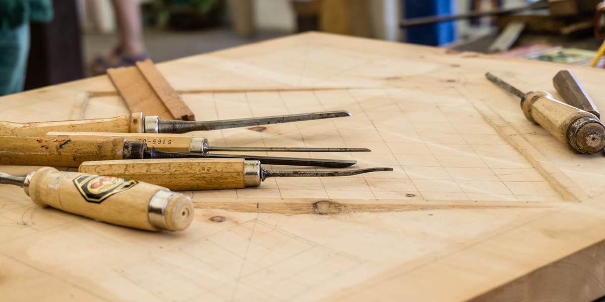 A woodworking bench with hand tools laid out, ready for a summer project